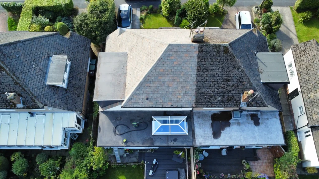 Image comparing the effectiveness of pressure washing on a house roof, clearly showing a dramatic visual improvement