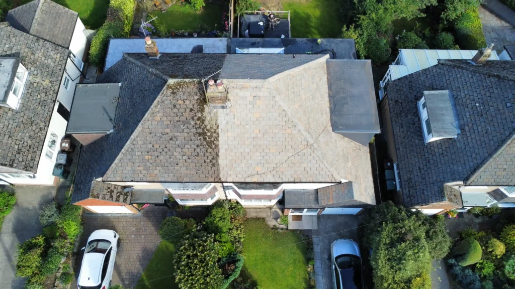 Aerial view showcasing Prestige Roofing's roof cleaning service, with a stark before-and-after split on a residential roof.